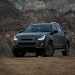 Isuzu pickup truck parked against the rugged mountain backdrop of Himachal Pradesh, India.